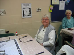 elderly resident sits at table